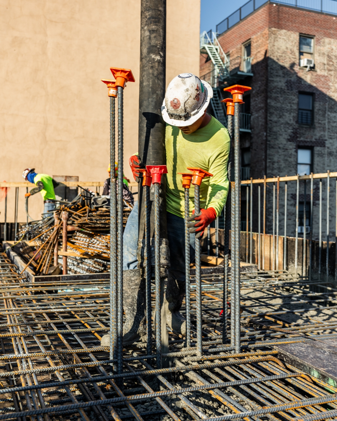 Titan worker tying rebar on active site — early construction phase