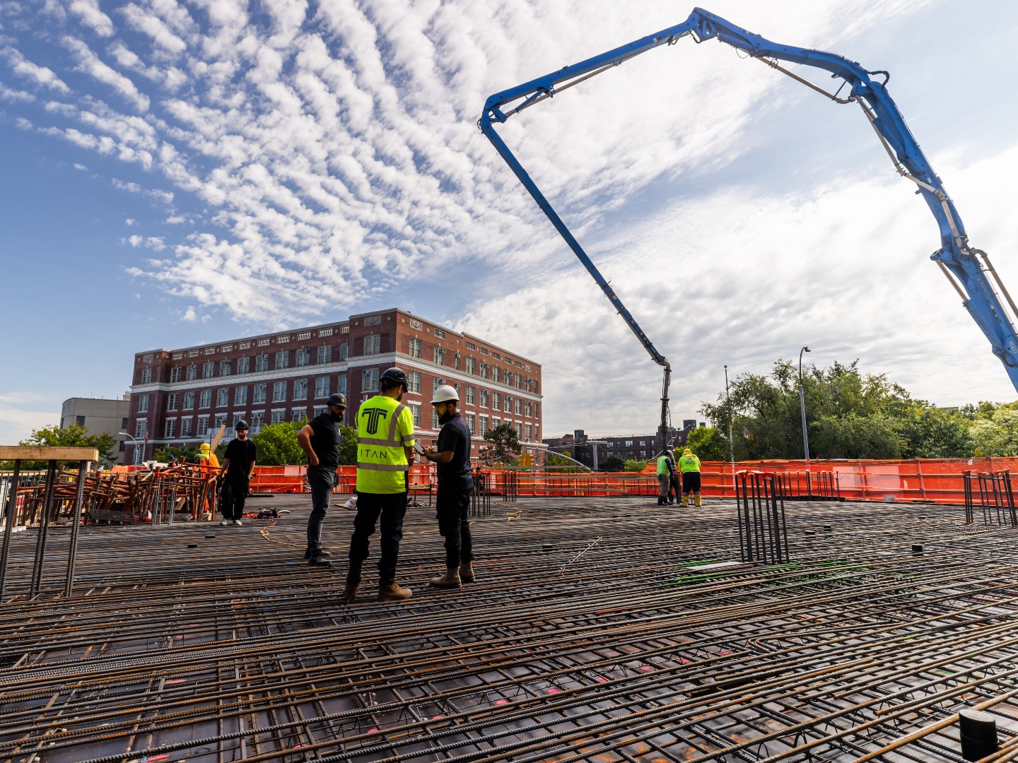 Titan crew on rebar grid with pump crane — 1701 Macombs Road, Bronx